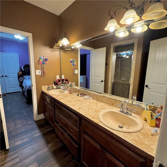 bathroom with hardwood / wood-style floors, vanity, and an enclosed shower