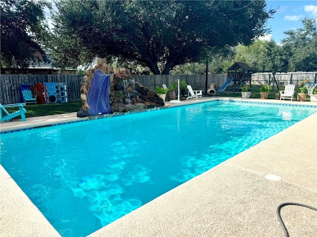 view of swimming pool featuring a playground