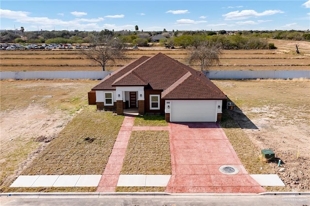 view of front of house with a garage and a rural view