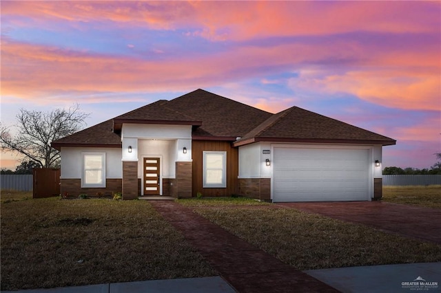 prairie-style house featuring a yard and a garage