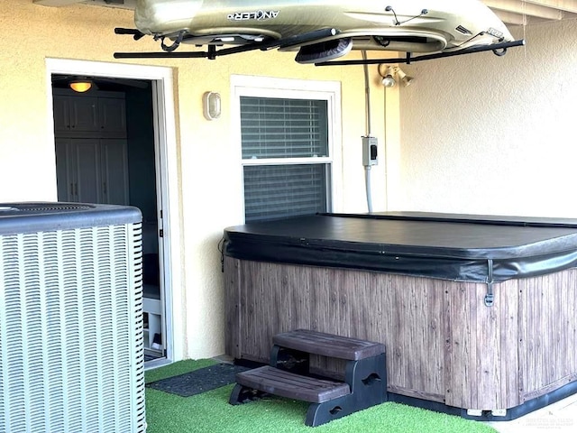 exterior space featuring central air condition unit and a hot tub