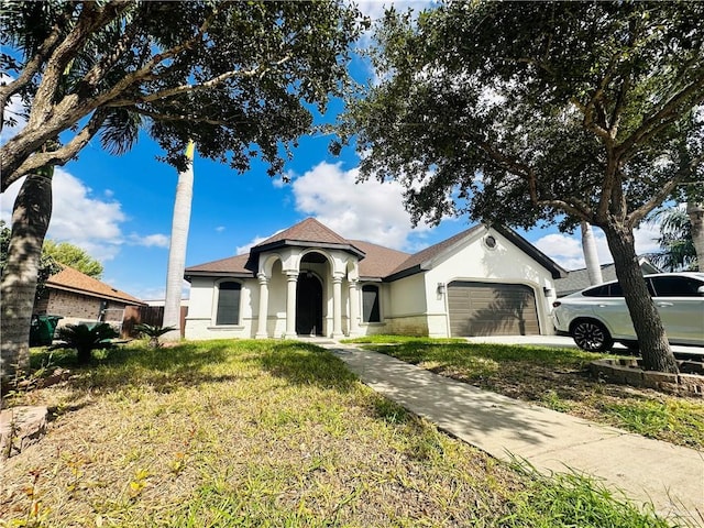 view of front of property featuring a garage and a front lawn