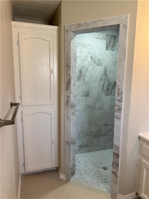 1401 Royola St, Mission, TX 78572 - bathroom with vanity, a tile shower, tile patterned flooring, and baseboards
