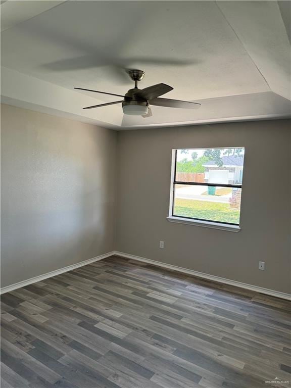 spare room featuring ceiling fan and dark wood-type flooring