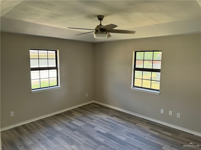 unfurnished room with ceiling fan and dark wood-type flooring