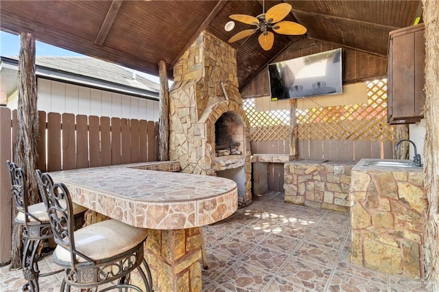 view of patio / terrace with ceiling fan and a bar