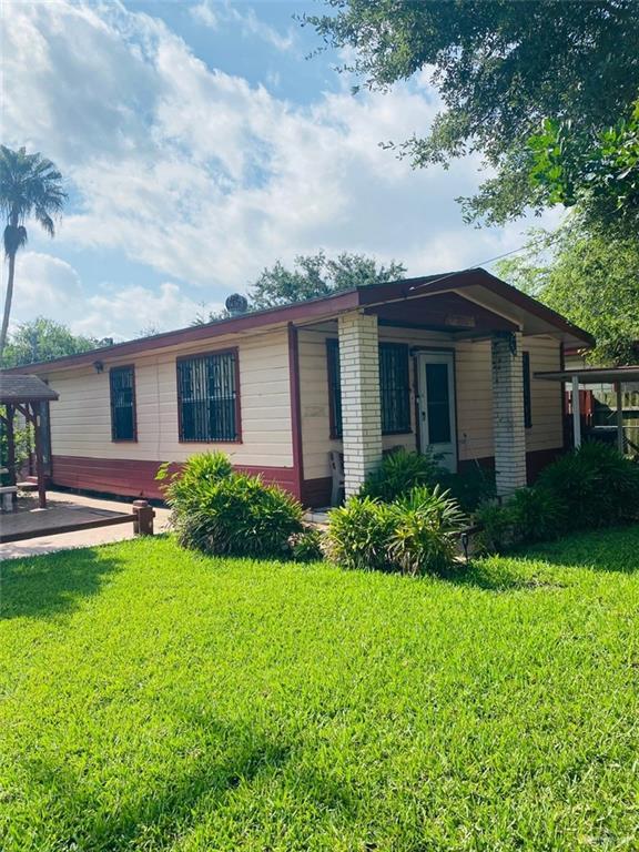 1204 E 2nd St, Weslaco, TX 78596 - view of front of home featuring a front lawn and brick siding