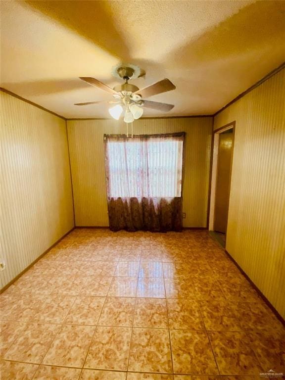 1204 E 2nd St, Weslaco, TX 78596 - empty room featuring a ceiling fan, wood walls, and a textured ceiling