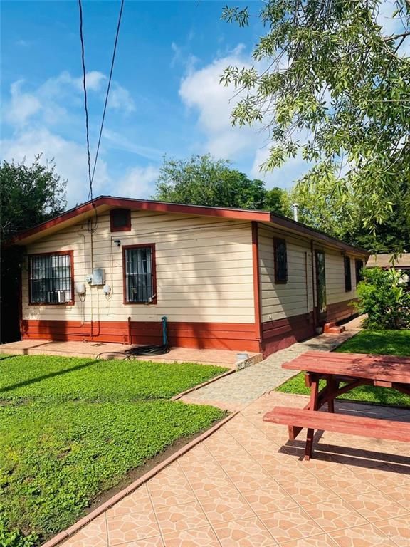 1204 E 2nd St, Weslaco, TX 78596 - rear view of property with a lawn and a patio area