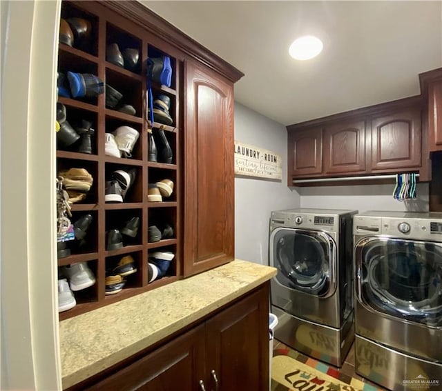 clothes washing area featuring washing machine and dryer and cabinets