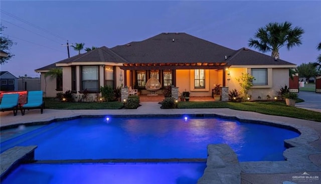 back house at dusk featuring a patio area