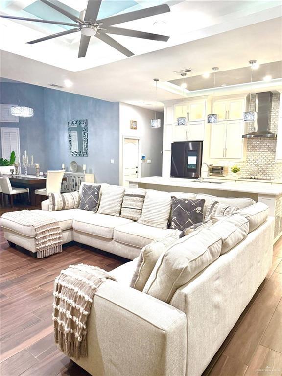 living room with ceiling fan, sink, and dark hardwood / wood-style floors