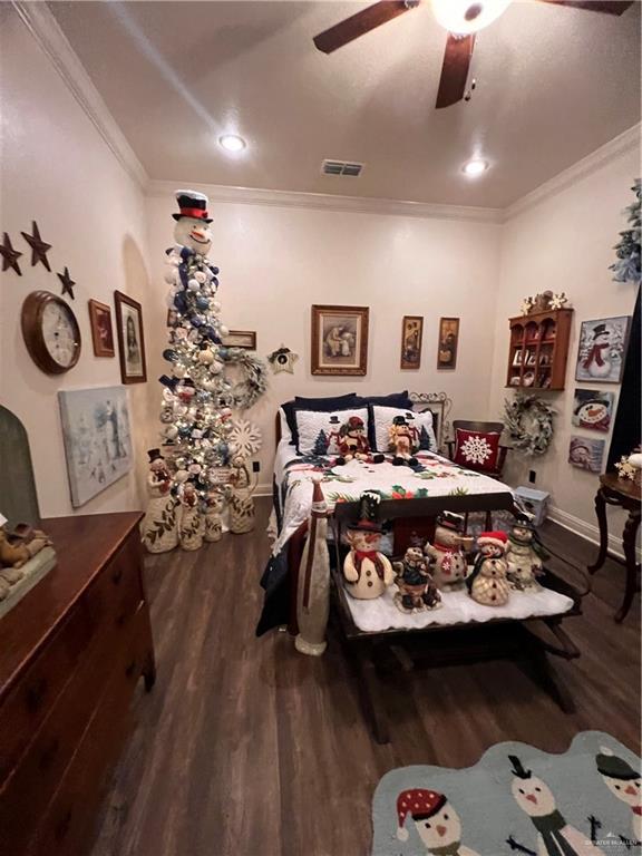 bedroom featuring hardwood / wood-style flooring, ceiling fan, and ornamental molding