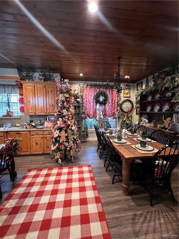 dining area featuring a chandelier, dark hardwood / wood-style floors, and wooden ceiling