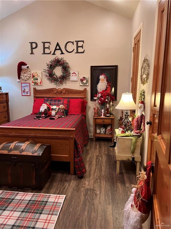 bedroom featuring dark hardwood / wood-style flooring and vaulted ceiling