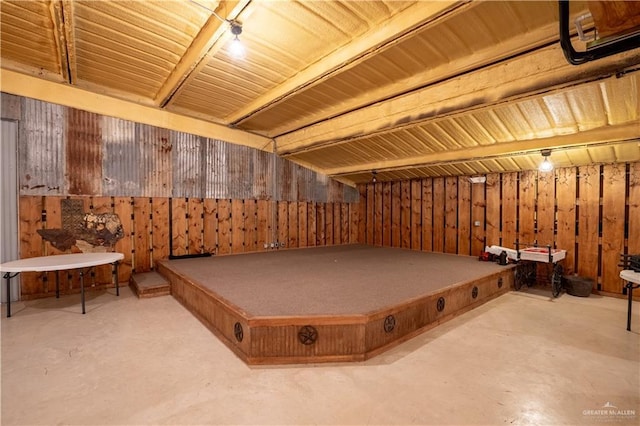 rec room with concrete flooring and wood walls