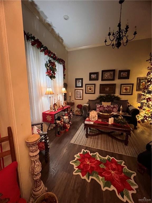 sitting room with ornamental molding, a notable chandelier, and hardwood / wood-style flooring