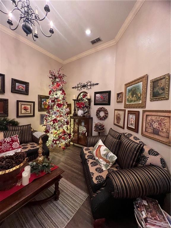 living room featuring hardwood / wood-style floors, ornamental molding, and an inviting chandelier