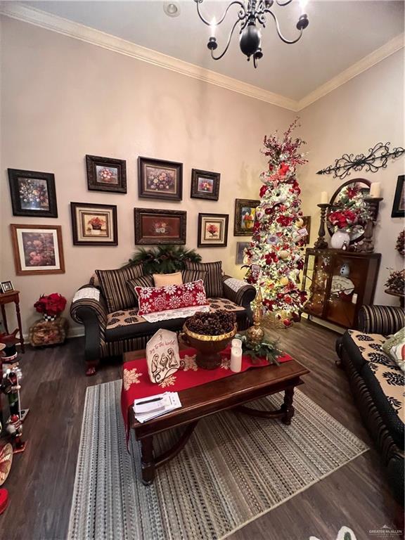 living room featuring a chandelier, dark hardwood / wood-style floors, and ornamental molding