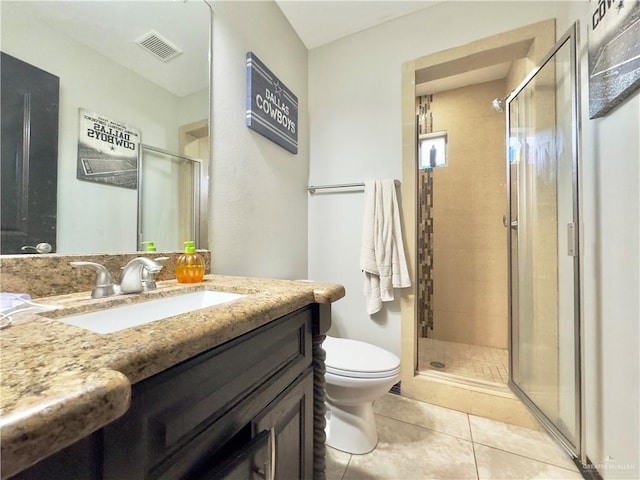 bathroom with a shower with door, toilet, tile patterned floors, and vanity