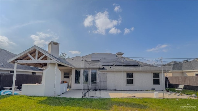 back of property featuring a patio area and a lawn