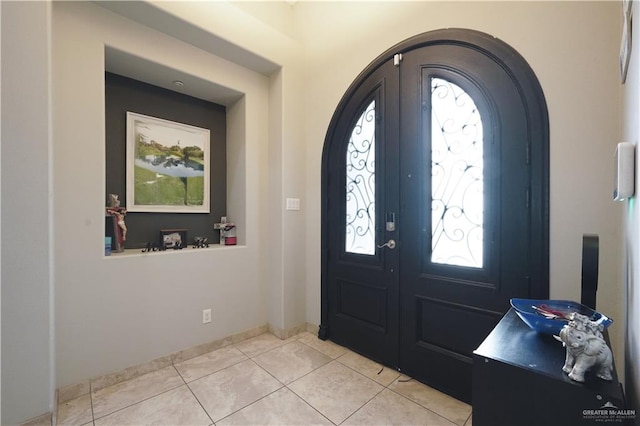 foyer entrance with light tile patterned floors and french doors