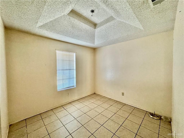 spare room with light tile patterned flooring and a textured ceiling