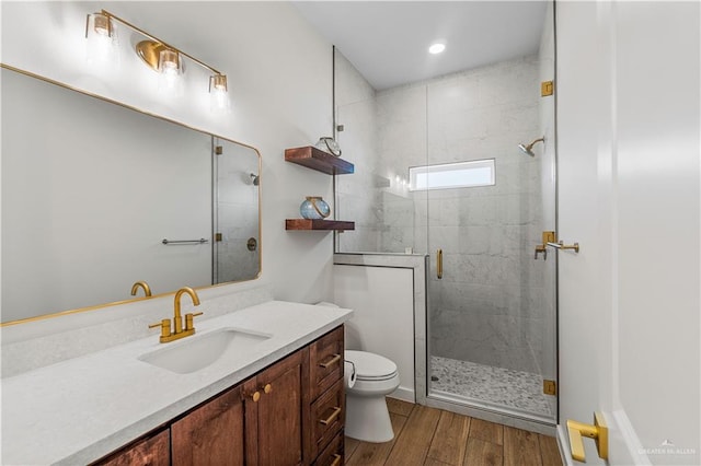 bathroom with vanity, hardwood / wood-style floors, an enclosed shower, and toilet