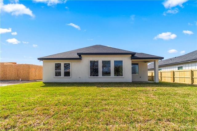 rear view of house featuring a yard