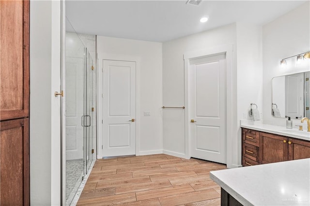 bathroom featuring vanity, hardwood / wood-style floors, and a shower with shower door