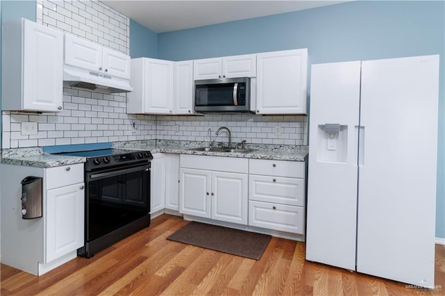 kitchen with white cabinetry, black electric range, white fridge with ice dispenser, and light hardwood / wood-style flooring