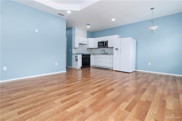 kitchen featuring white cabinetry, white fridge with ice dispenser, sink, and light hardwood / wood-style flooring