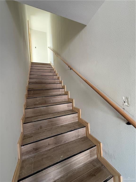 stairs featuring wood finished floors