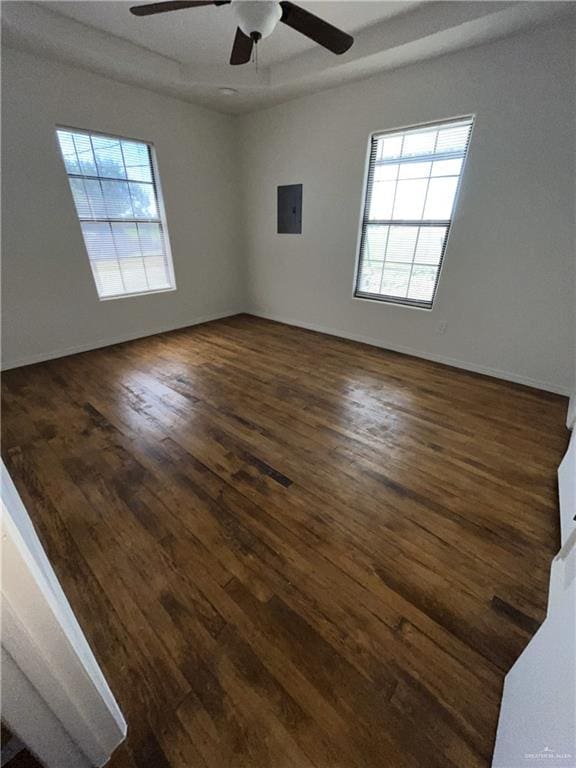 spare room featuring electric panel, ceiling fan, and dark wood-type flooring