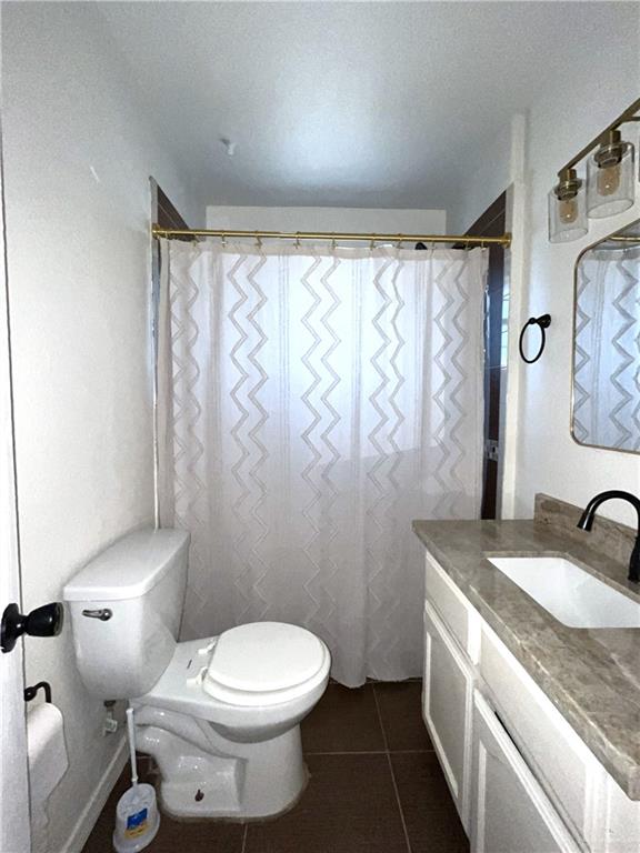 bathroom featuring tile patterned flooring, vanity, and toilet