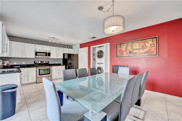 2201 S Jackson Road I Unit 7, Pharr, TX 78577 - dining area with stacked washer / drying machine, light tile patterned floors, and a textured wall