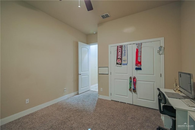 unfurnished office featuring a ceiling fan, carpet floors, baseboards, and visible vents
