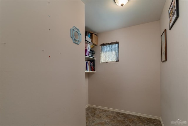 spare room with baseboards