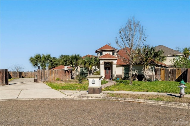 view of front of home with fence and a front lawn