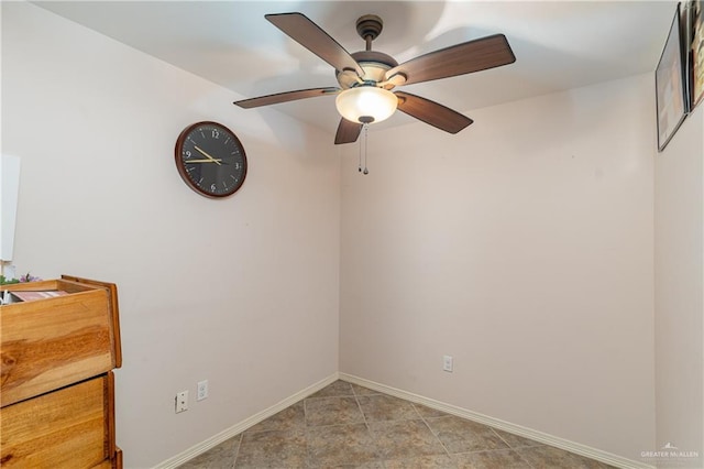 empty room with ceiling fan and baseboards