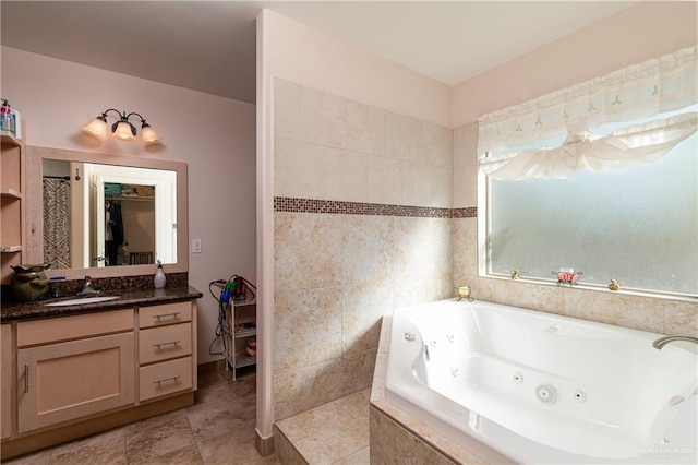 full bath featuring a spacious closet, vanity, a whirlpool tub, and tile patterned floors