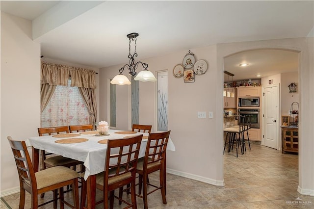 dining area featuring arched walkways and baseboards