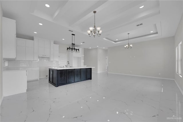 kitchen featuring a spacious island, white cabinetry, decorative light fixtures, a tray ceiling, and a notable chandelier