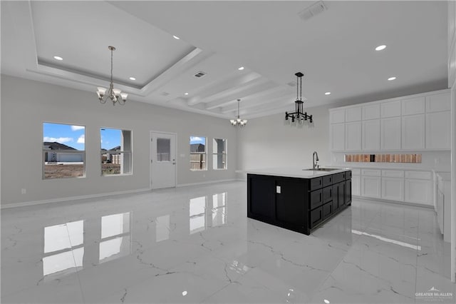 kitchen featuring hanging light fixtures, white cabinetry, a notable chandelier, and a tray ceiling