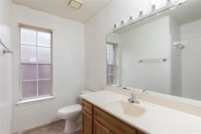 2109 E 28th St, Mission, TX 78574 - full bathroom featuring a textured ceiling, toilet, a tile shower, tile patterned floors, and vanity