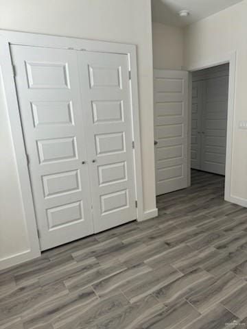 unfurnished bedroom featuring wood-type flooring and a closet