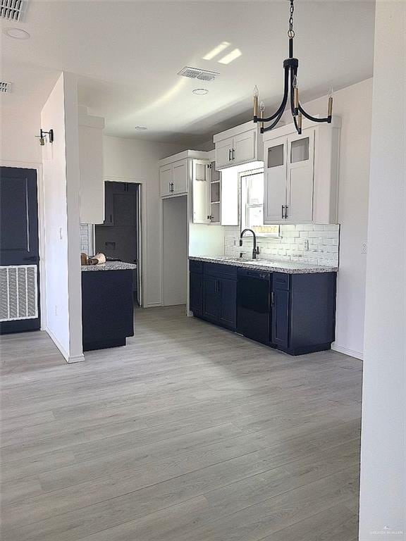 kitchen with white cabinetry, sink, an inviting chandelier, pendant lighting, and light wood-type flooring