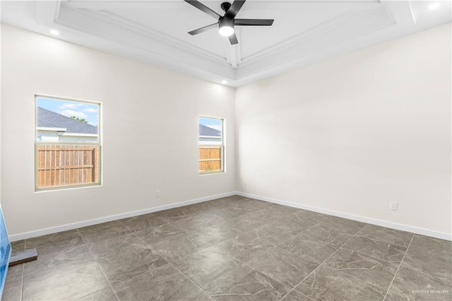 spare room with a raised ceiling, ceiling fan, and ornamental molding