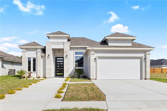 view of front of property with a front yard, a garage, and central air condition unit