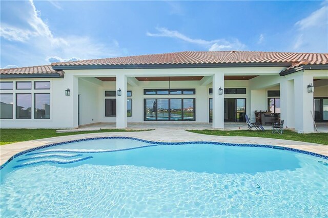 exterior space featuring an outdoor pool, a patio area, and stucco siding